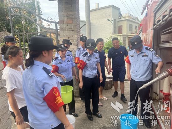 民輔警跟隨消防水車作業(yè)，通過肩挑手提的方式將清水送入行動(dòng)不便的老年、殘障村民的家中（通訊員 李麗君 攝） (3).jpg.jpg