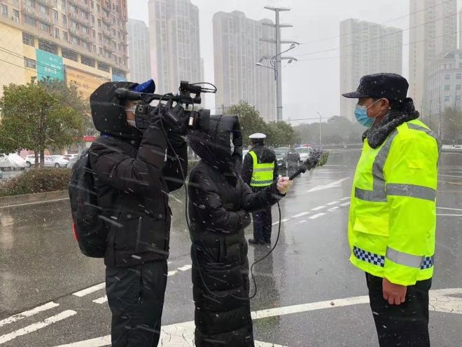 孝感市融媒體中心楊亞玲（風(fēng)雪中，采訪疫情期間重返一線的退休警察）_副本.jpg.jpg